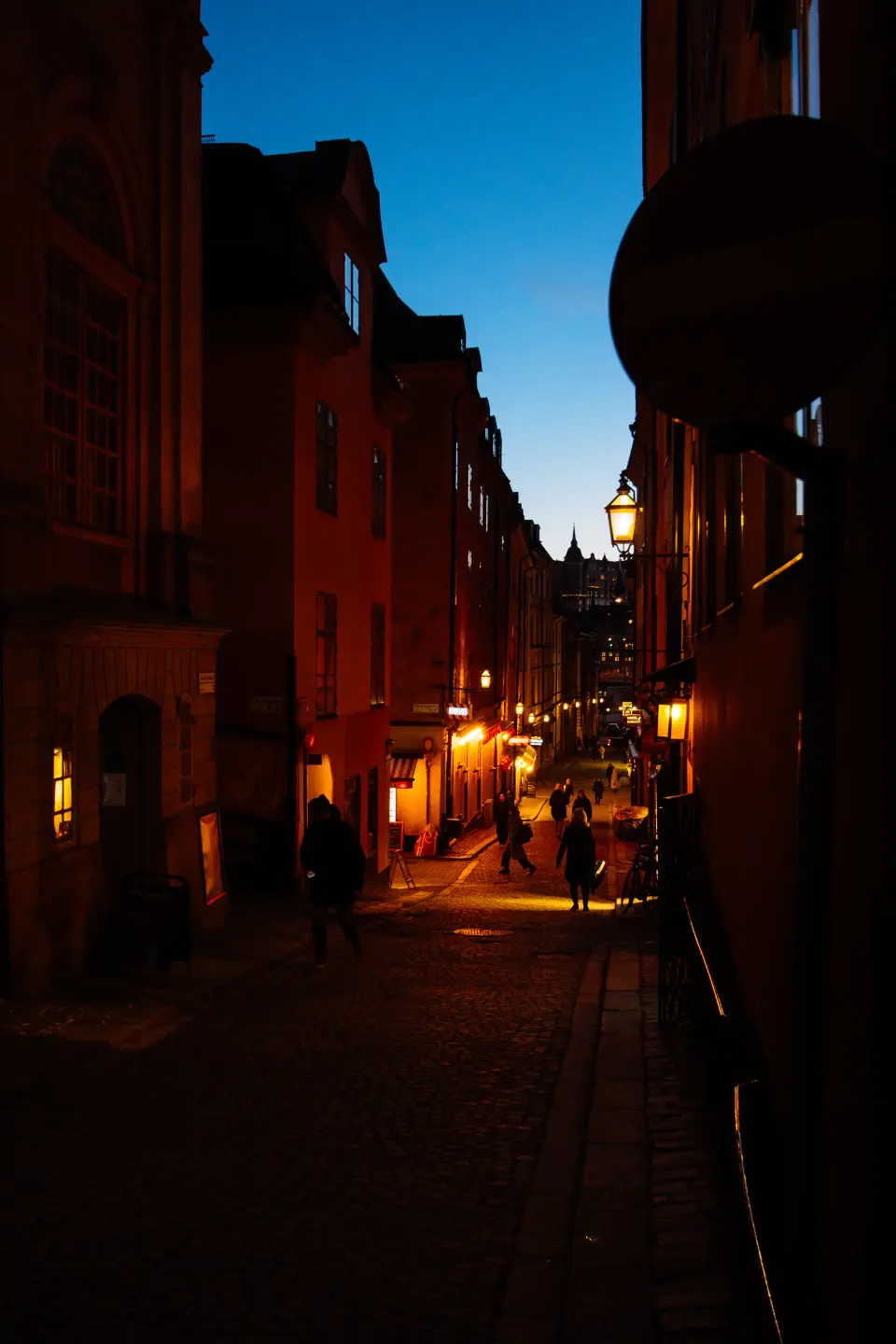 Vicolo cittadino illuminato di sera.
