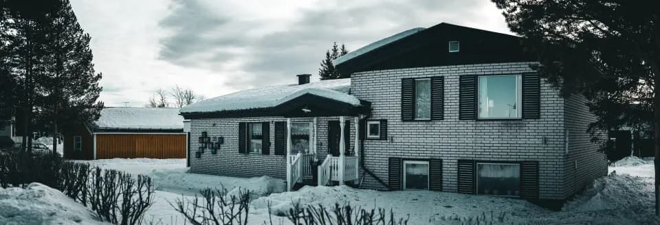 Casa chiara in un paesaggio invernale.