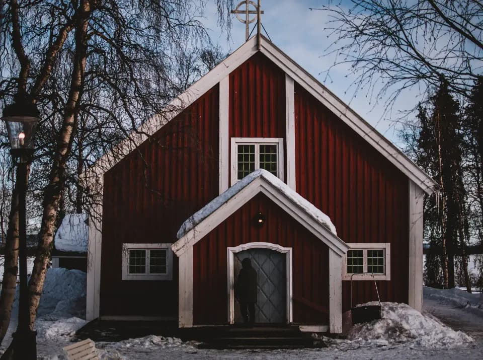 Chiesa rossa tra gli alberi.