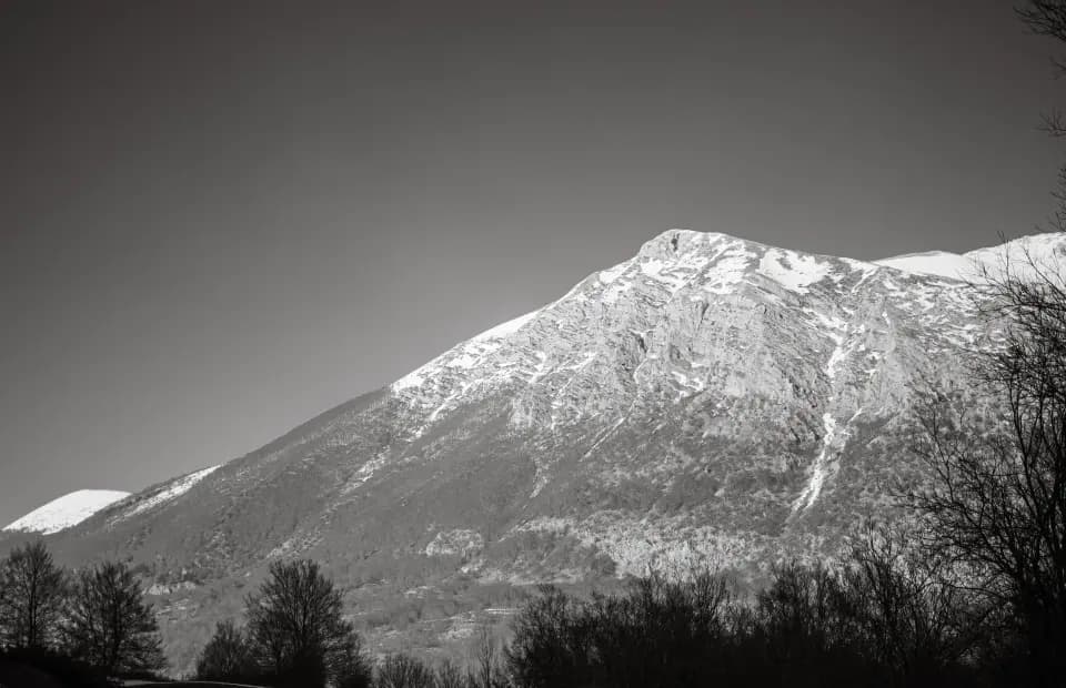 Montagna innevata in bianco e nero.