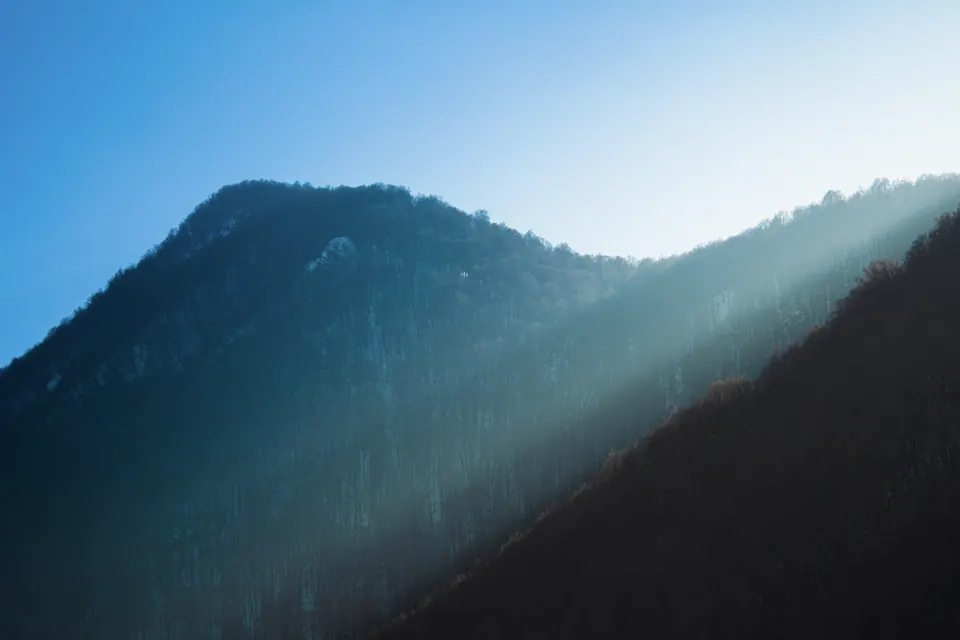 Raggi di luce che scendono tra le montagne.